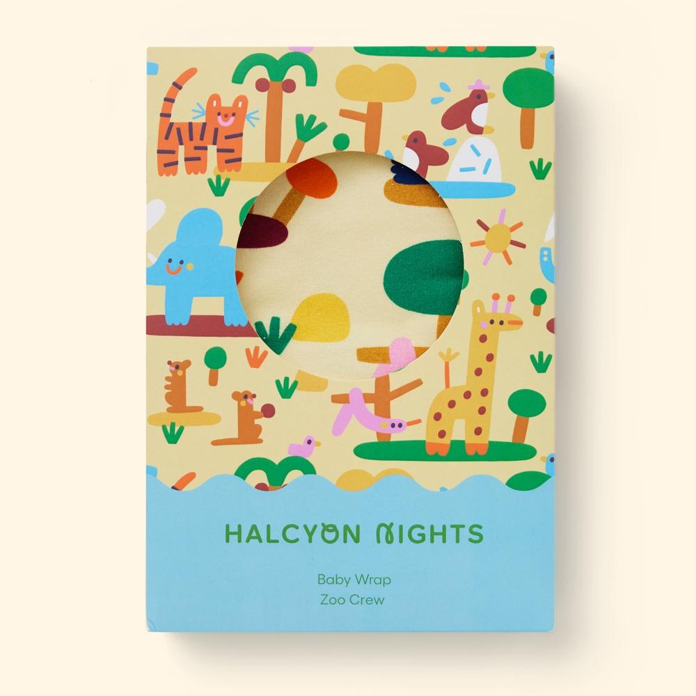 Halcyon Nights Zoo Crew baby wrap in a card box printed with a tiger, an elephant, a giraffe and meerkats, with a round window onto the fabric